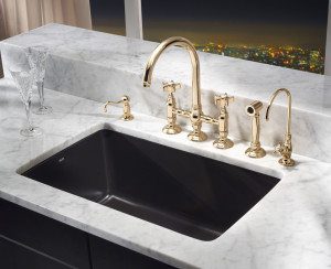 Rohl Satin Brass Faucet and Black Sink in a black and white kitchen