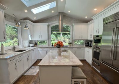 New custom white kitchen cabinetry wood floor stainless appliances